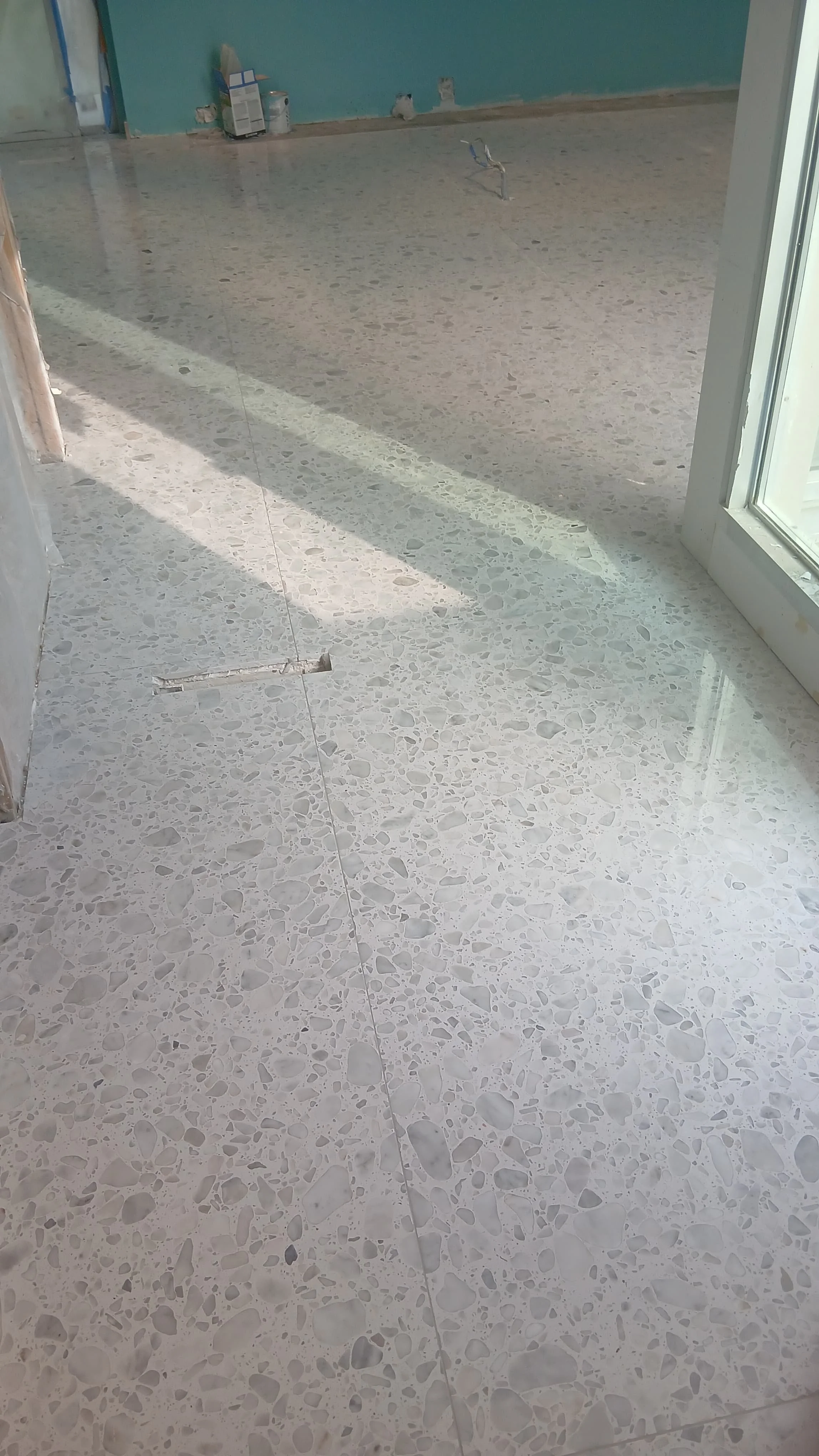 Finished large-format terrazzo-look porcelain floor with clean joints and a polished surface.