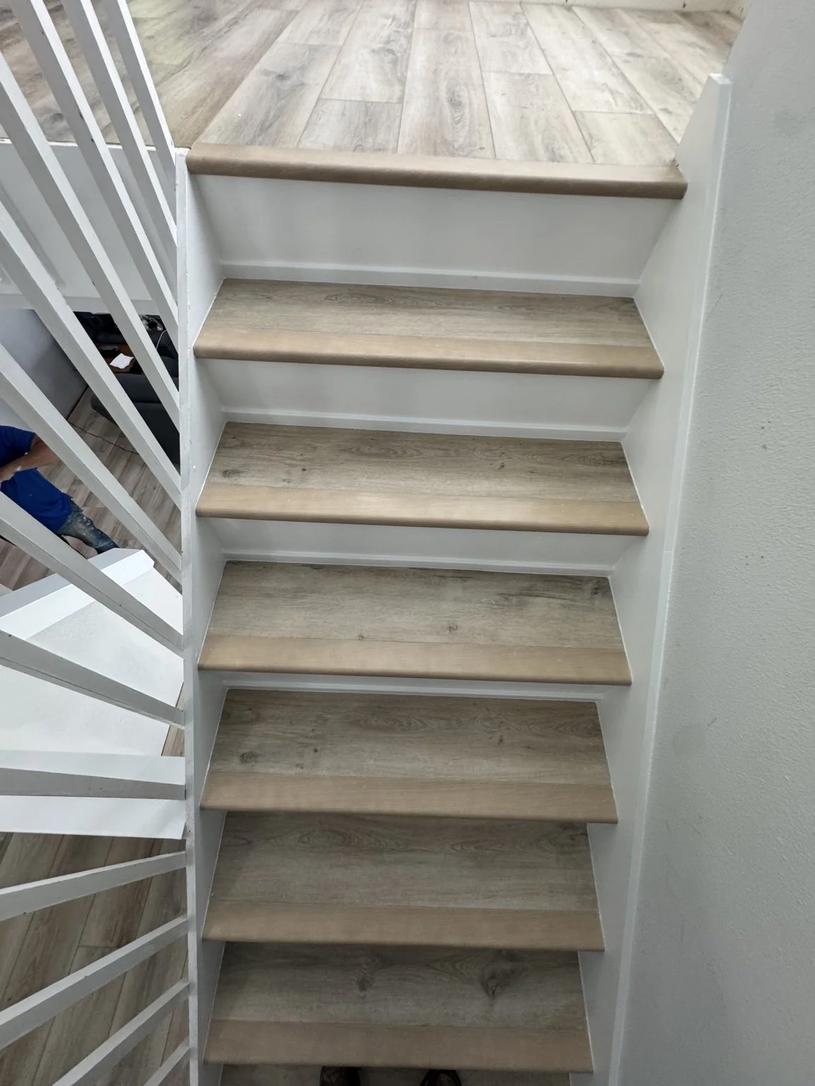 Light wood-look LVP flooring with matching stair treads and white risers.
