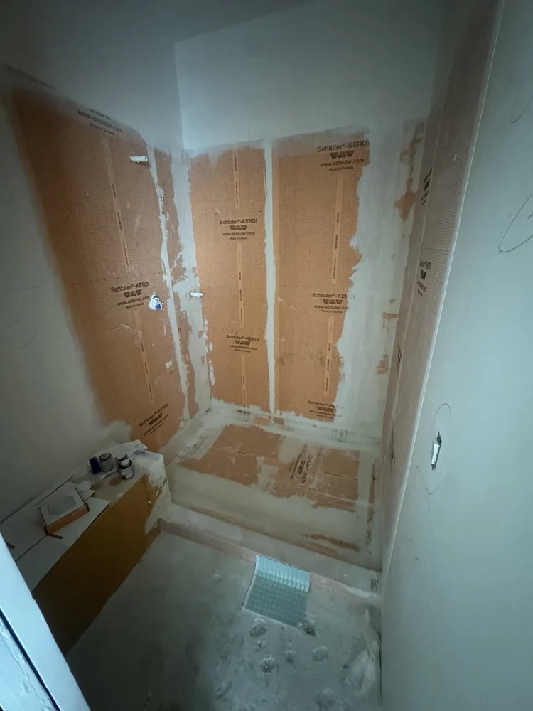 Schluter KERDI waterproofing preparation for a custom shower installation.