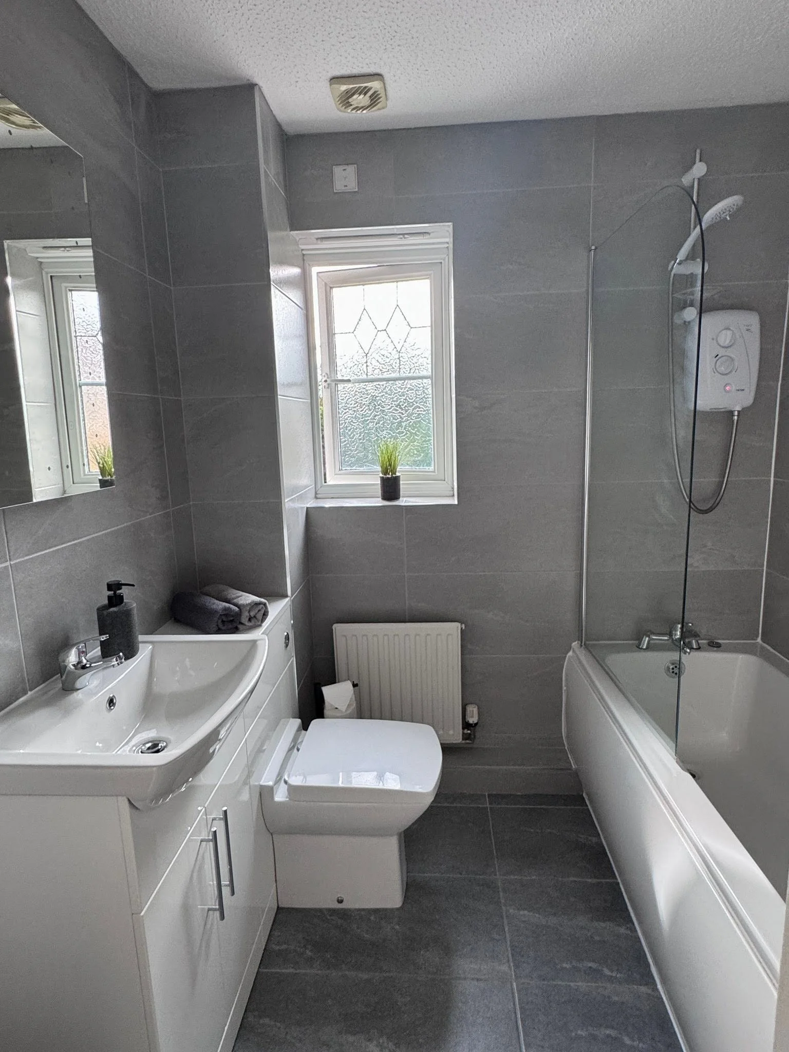 Spotless bathroom with gray tile and white vanity, professionally cleaned