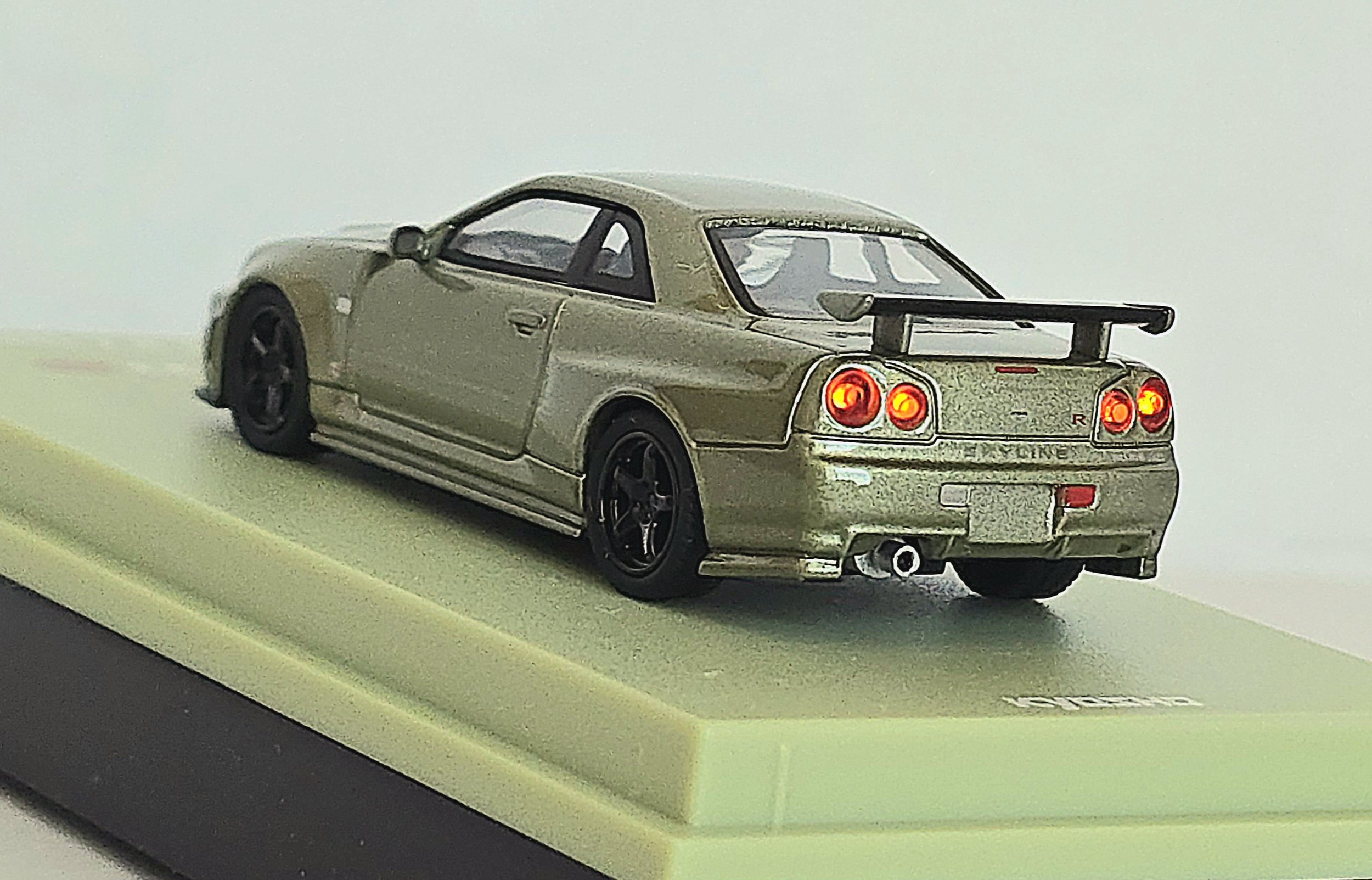 Silver die-cast sports car model on display base