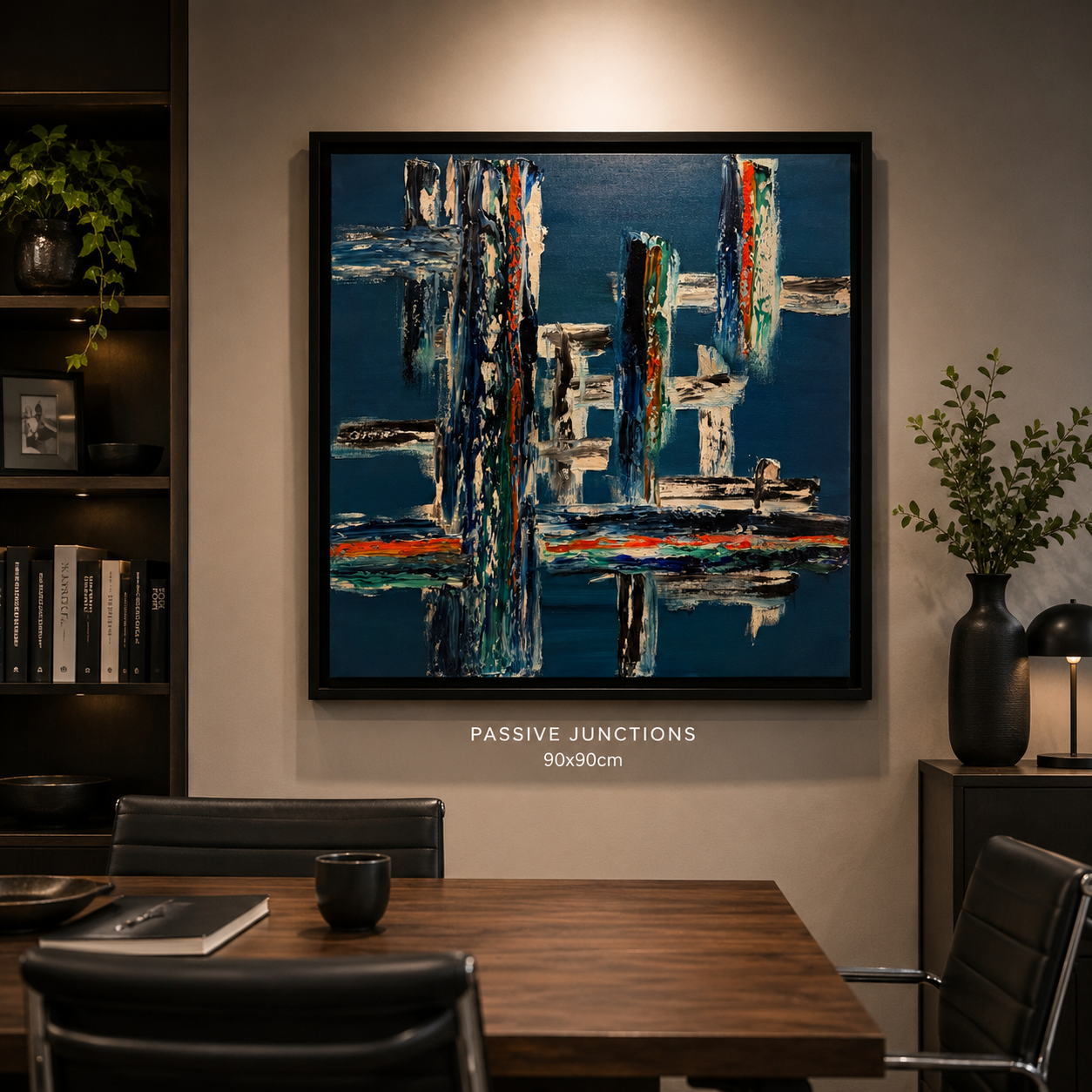 Abstract painting titled 'Passive Junctions' on a beige wall in a modern dining room with black furniture, a plant in a black vase, and bookshelves.