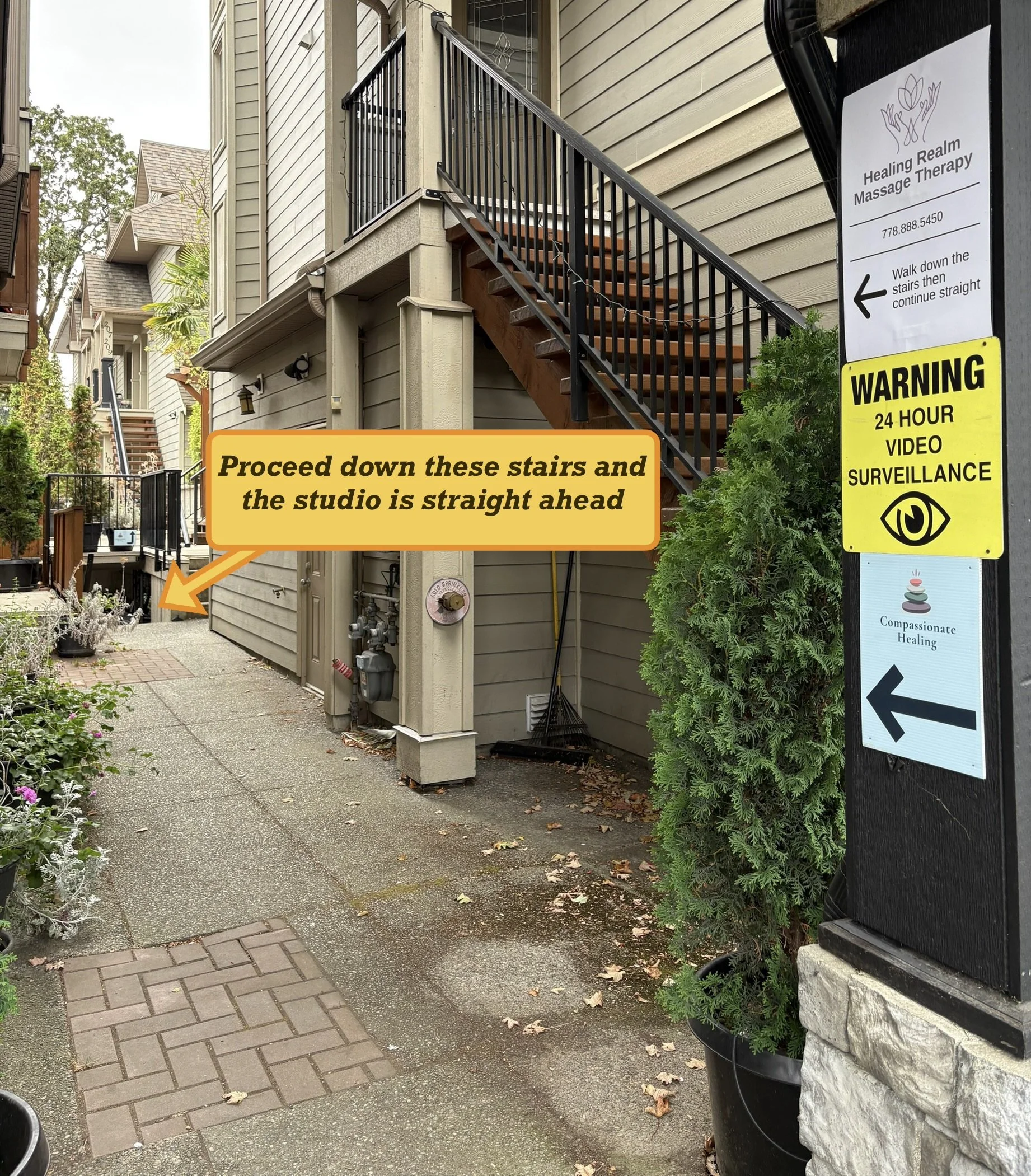 Building complex with yellow arrow pointing down the stairs saying "proceed down these stairs and the studio is straight ahead".