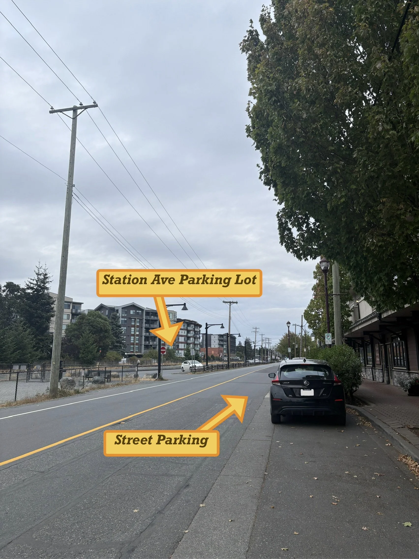 Two yellow arrows pointing to free car parking lot and street parking on Station Ave in front of the building complex.