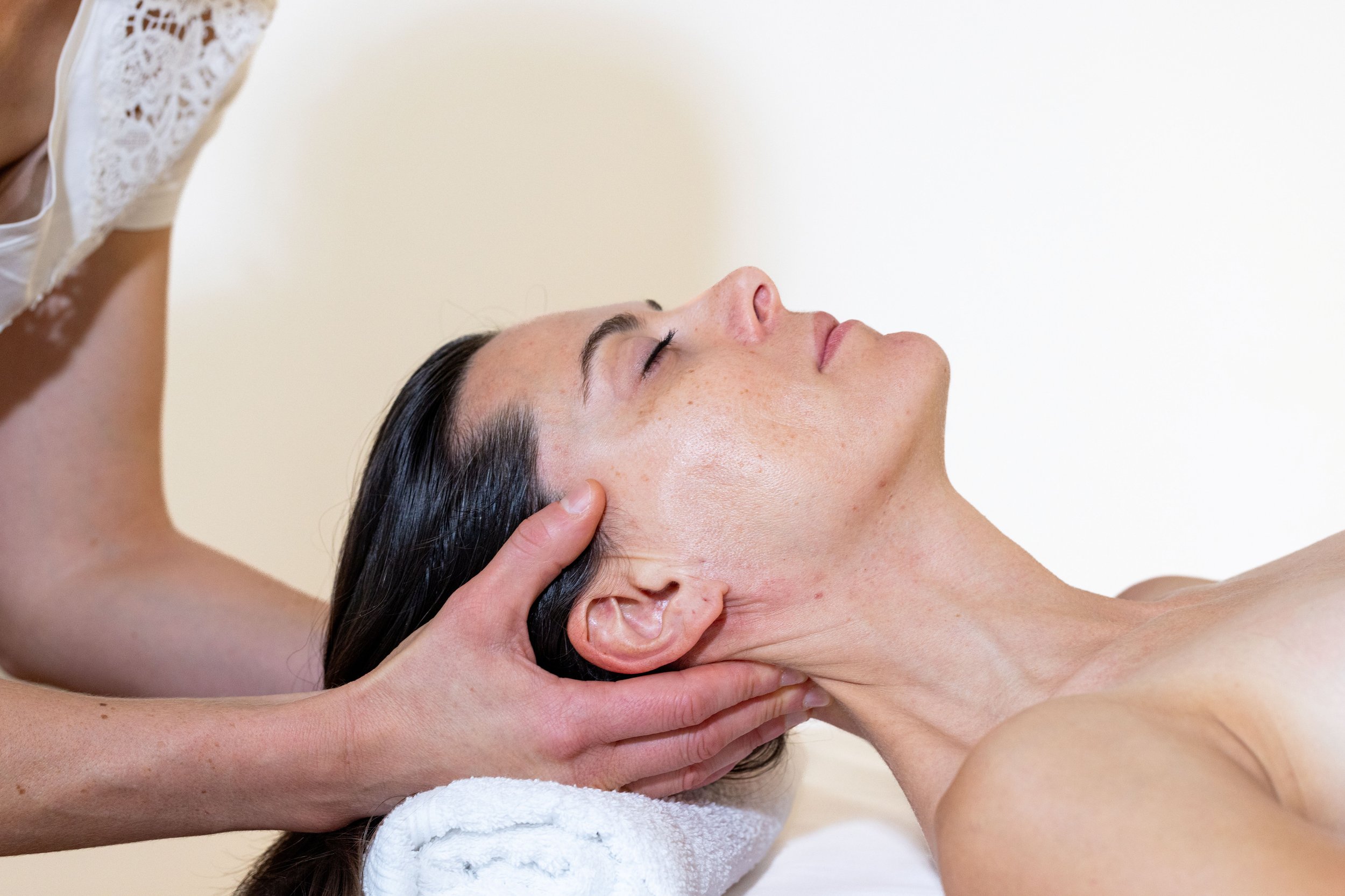 Kinésithérapeute qui active la circulation lymphatique en vidant les noeuds ganglionnaires cervicaux postérieurs suite à une chirurgie esthétique