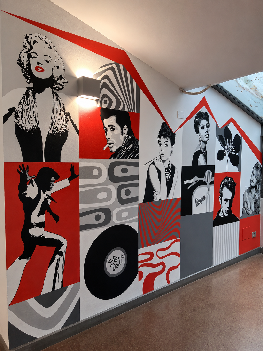 Murale decorativa con immagini in stile pop art di figure femminili e maschili, un disco in vinile con scritto 'Rock 'n' Roll', una macchina Vespa, un fiore e pattern geometrici in nero, bianco e rosso.