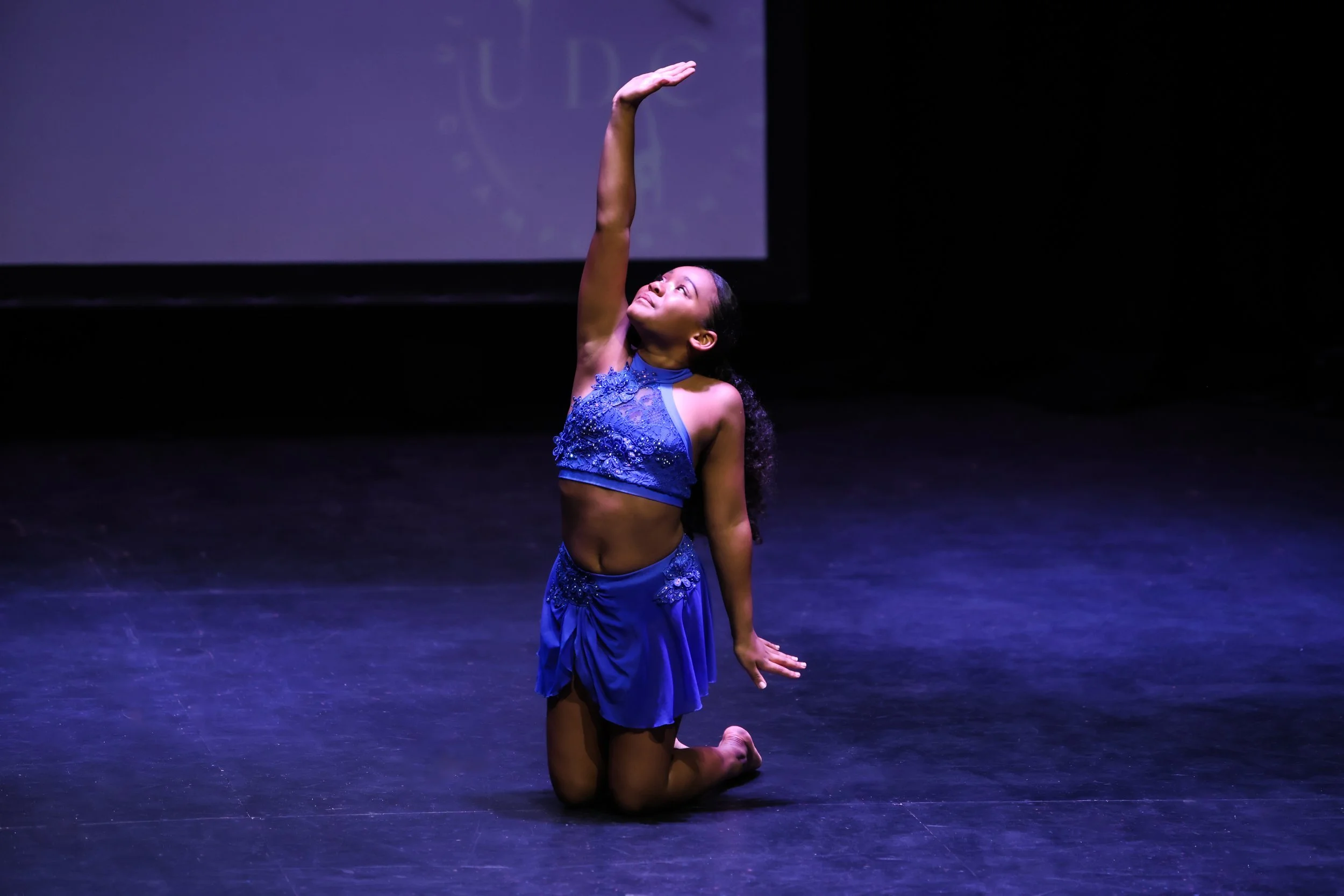 Dancer performing a contemporary solo, wearing a blue costume.