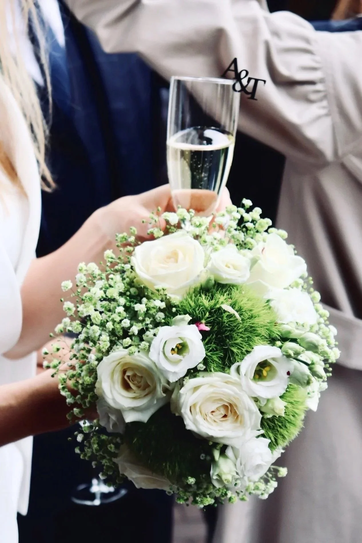 Hochzeitsfotografie Nähe Hannover, Bremen, Nienburg und Region, Hochzeitsstrauß mit weißen Rosen und Schleierkraut neben einem Glas Sekt