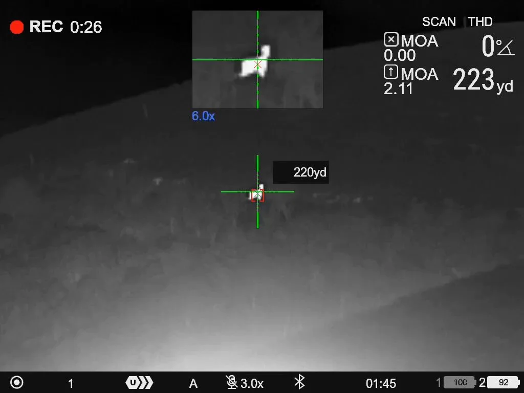 Night vision image showing a target at 220 yards with a crosshair overlay, and a small, distant object in the center of the crosshair.
