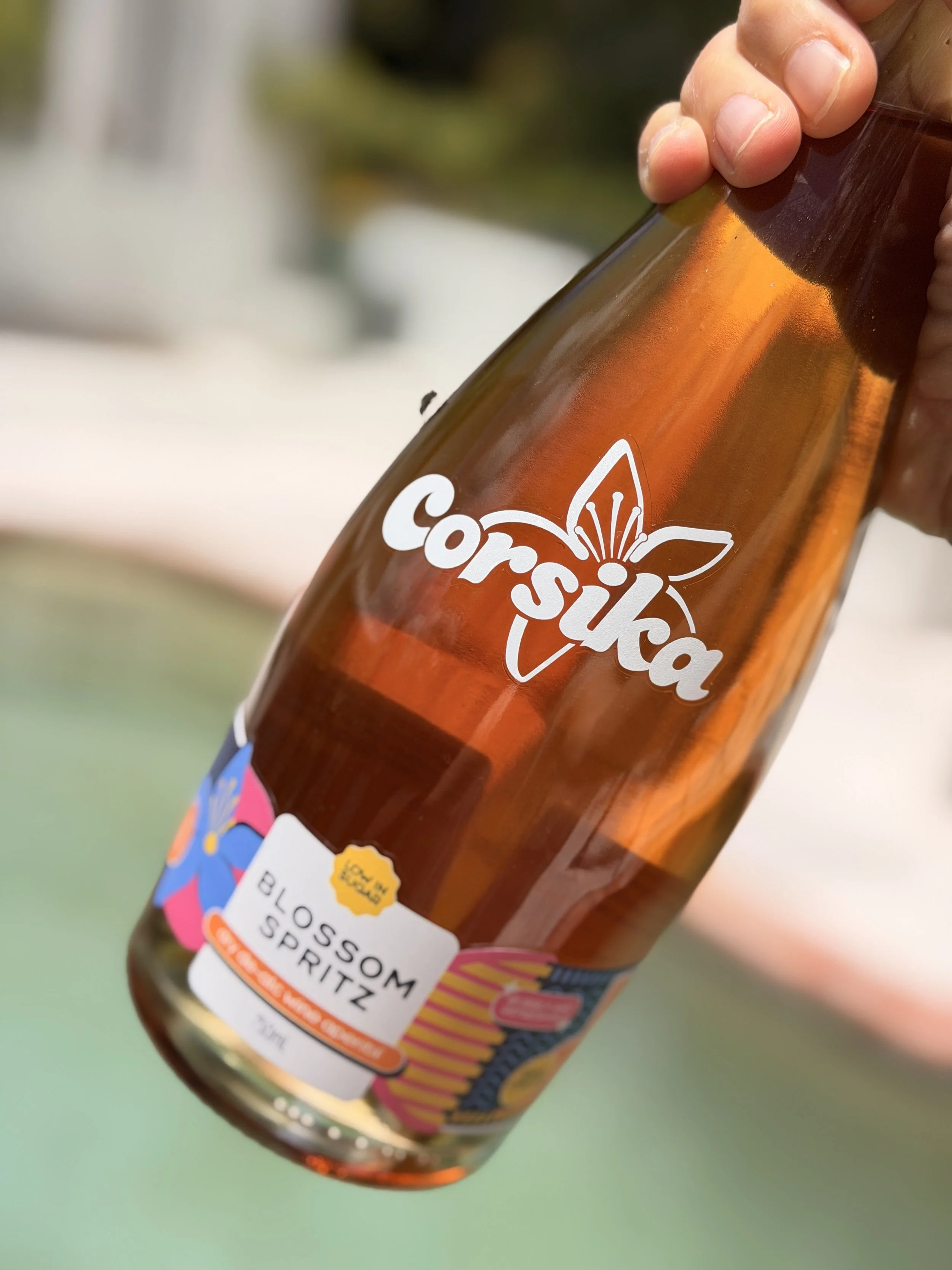 A person holding a bottle of Corsika sparkling blossom spritz