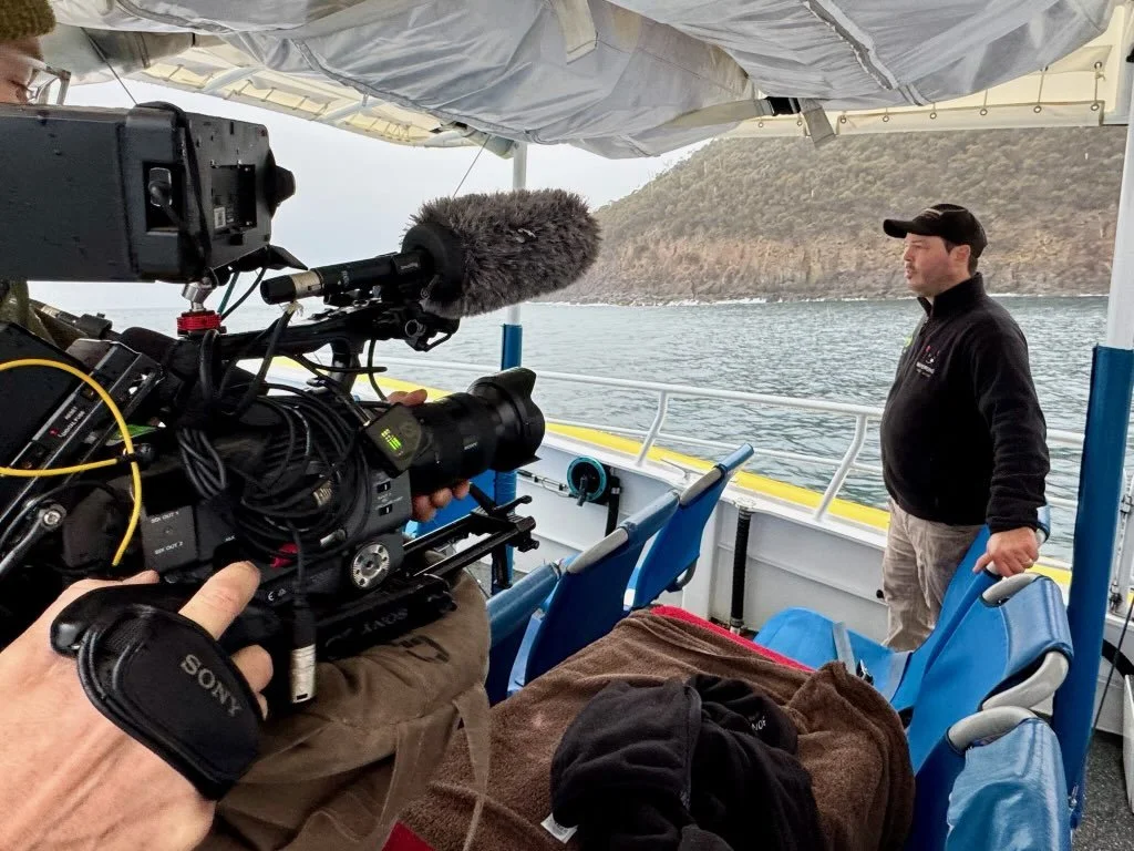 A photo of Greg Irons on a boat, being filmed as part of the filming for the Animal Sanctuary docuseries