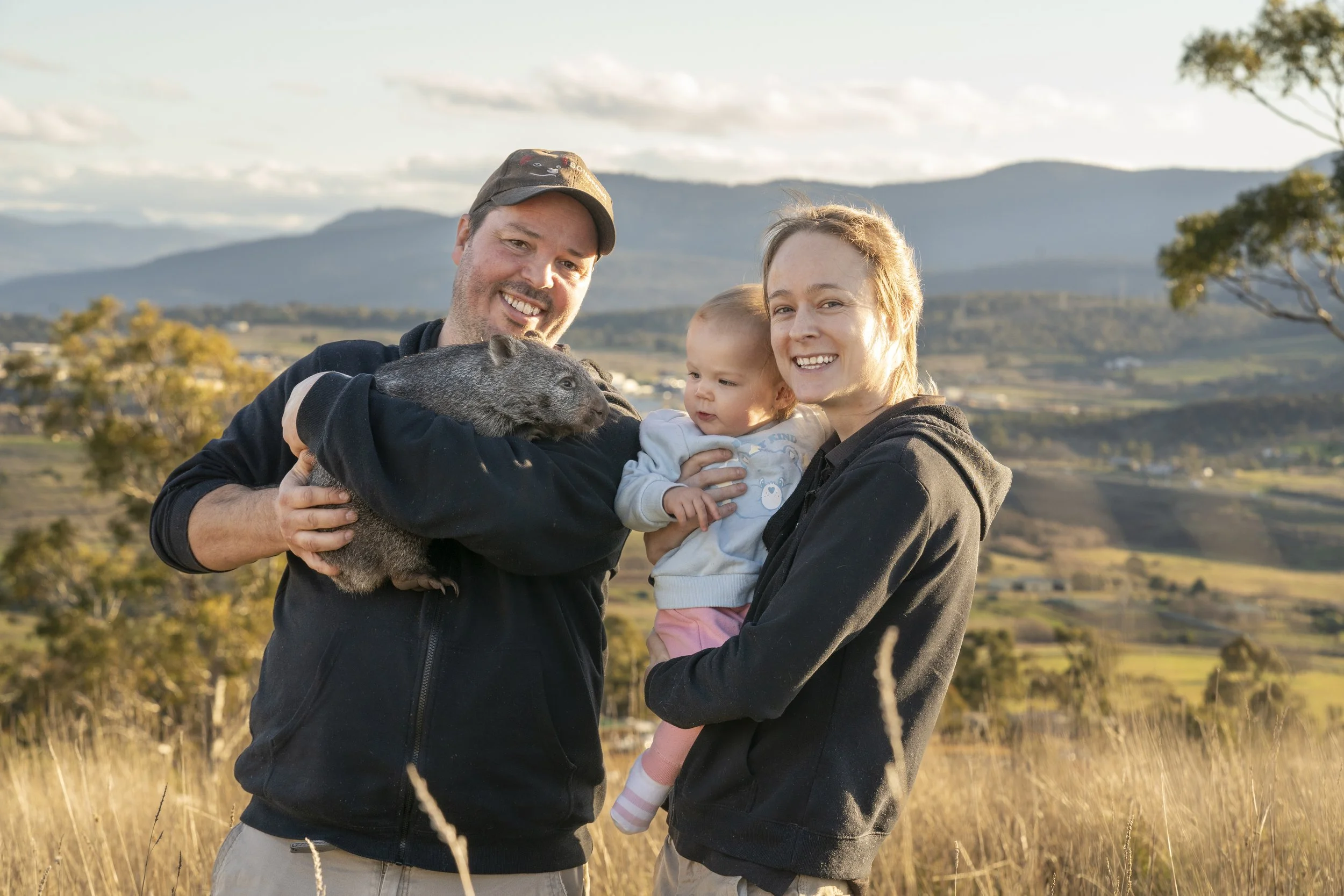 Greg Irons, Melissa Irons and Lara Irons holding a baby wombat
