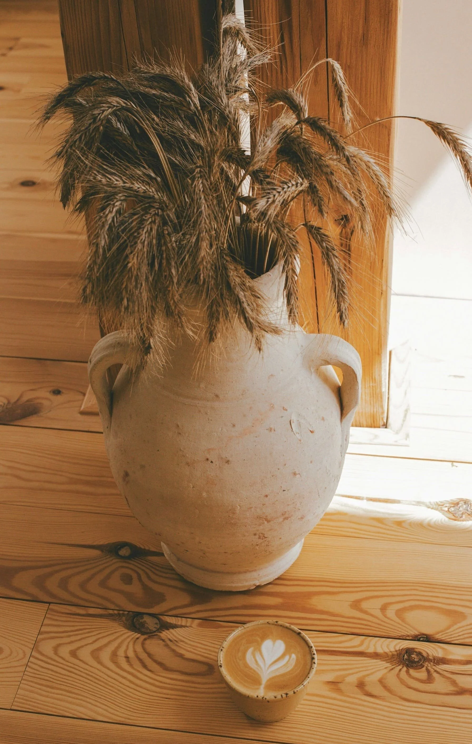 Stenen vaas met tarwe en koffie wat staat voor rust en vertrouwen terwijl ik werk vanuit intuïtie en met spirituele gidsen