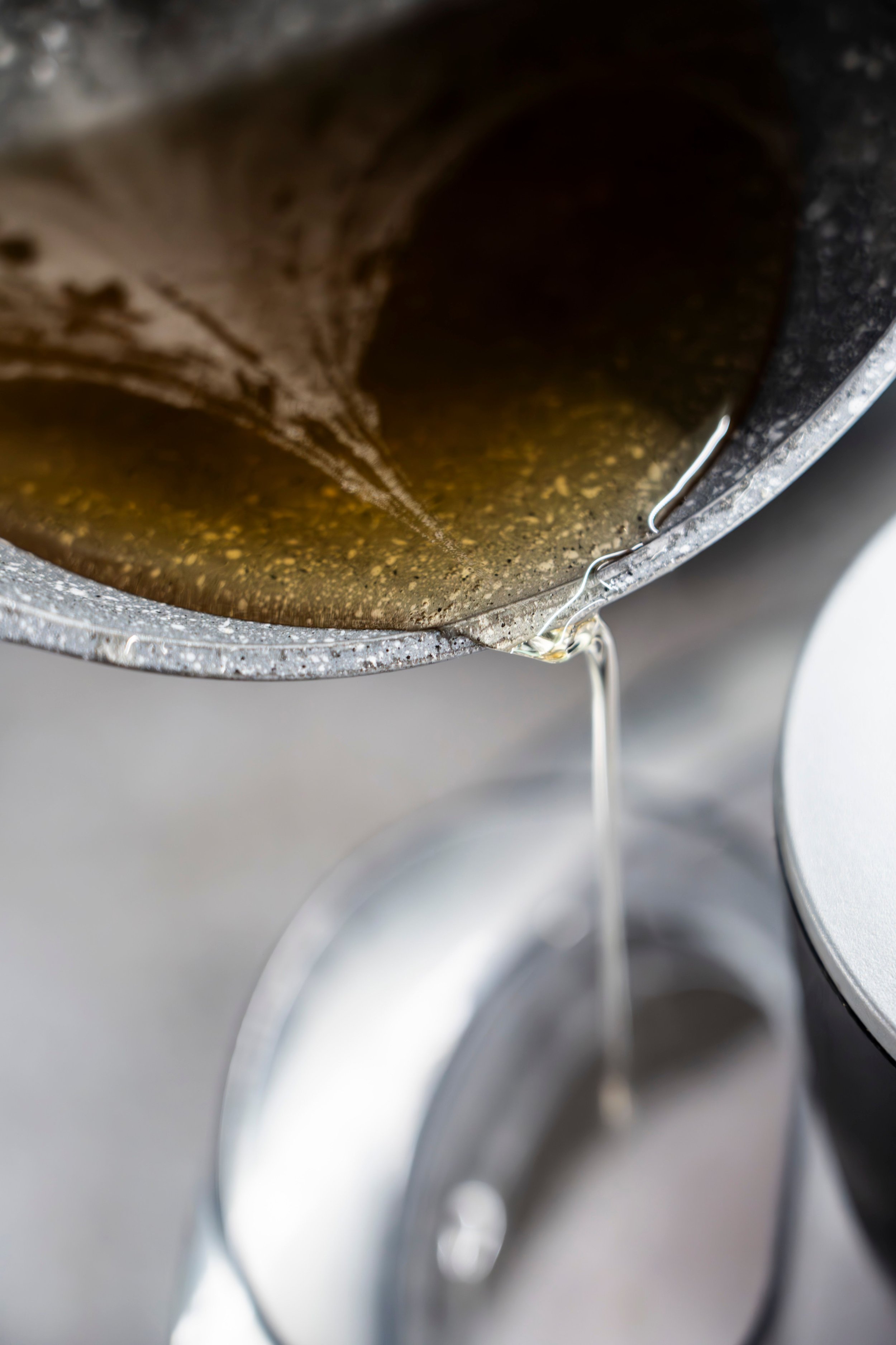 Close-up of a metallic paint can with brown paint inside, with a metal handle visible and some paint drips.