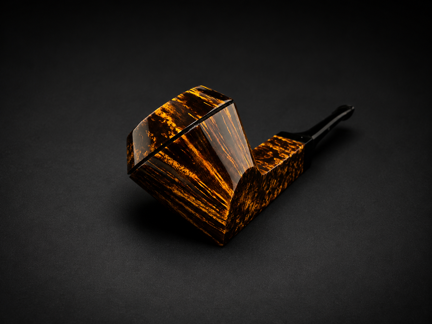 A tobacco pipe made of tortoise shell with a black mouthpiece on a black background.