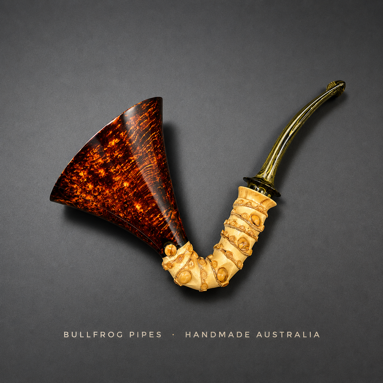 Handmade Australian bullfrog pipe with a tortoise shell bowl and a bone stem on a gray background