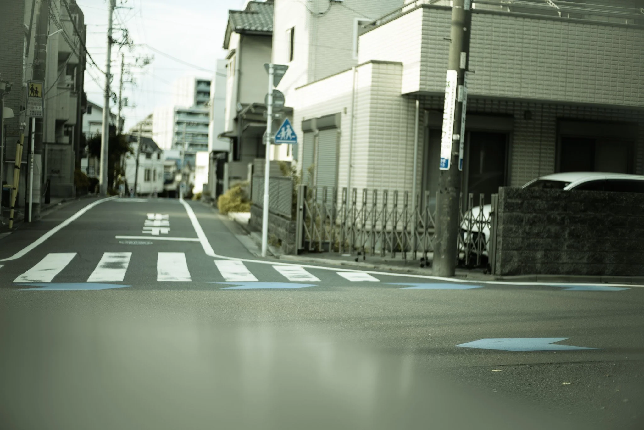 都市の交差点と道路標識、歩道に面した住宅街の風景