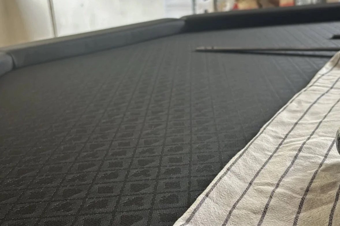 Eine Nahaufnahme einer Luxus Spieltuchs (Speed Cloth). Handarbeit, individuell, exklusive Verarbeitung. Perfekter Pokertisch. Armlehnen aus Leder. Pokertisch kaufen.