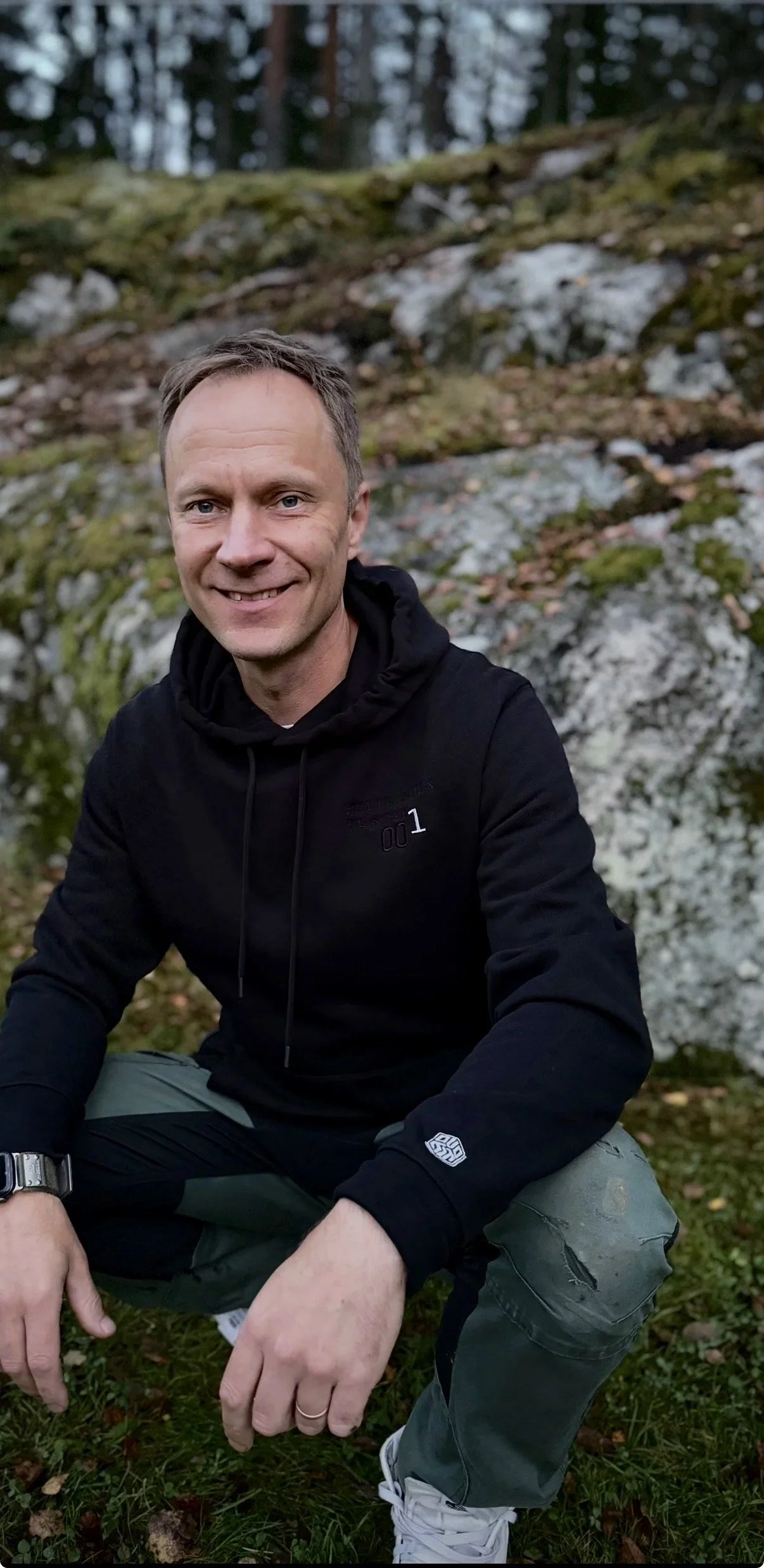 "Purosta brändin ja verkkokaupan rakentaja istuu kyykyssä kallion edessä mustassa hupparissa."