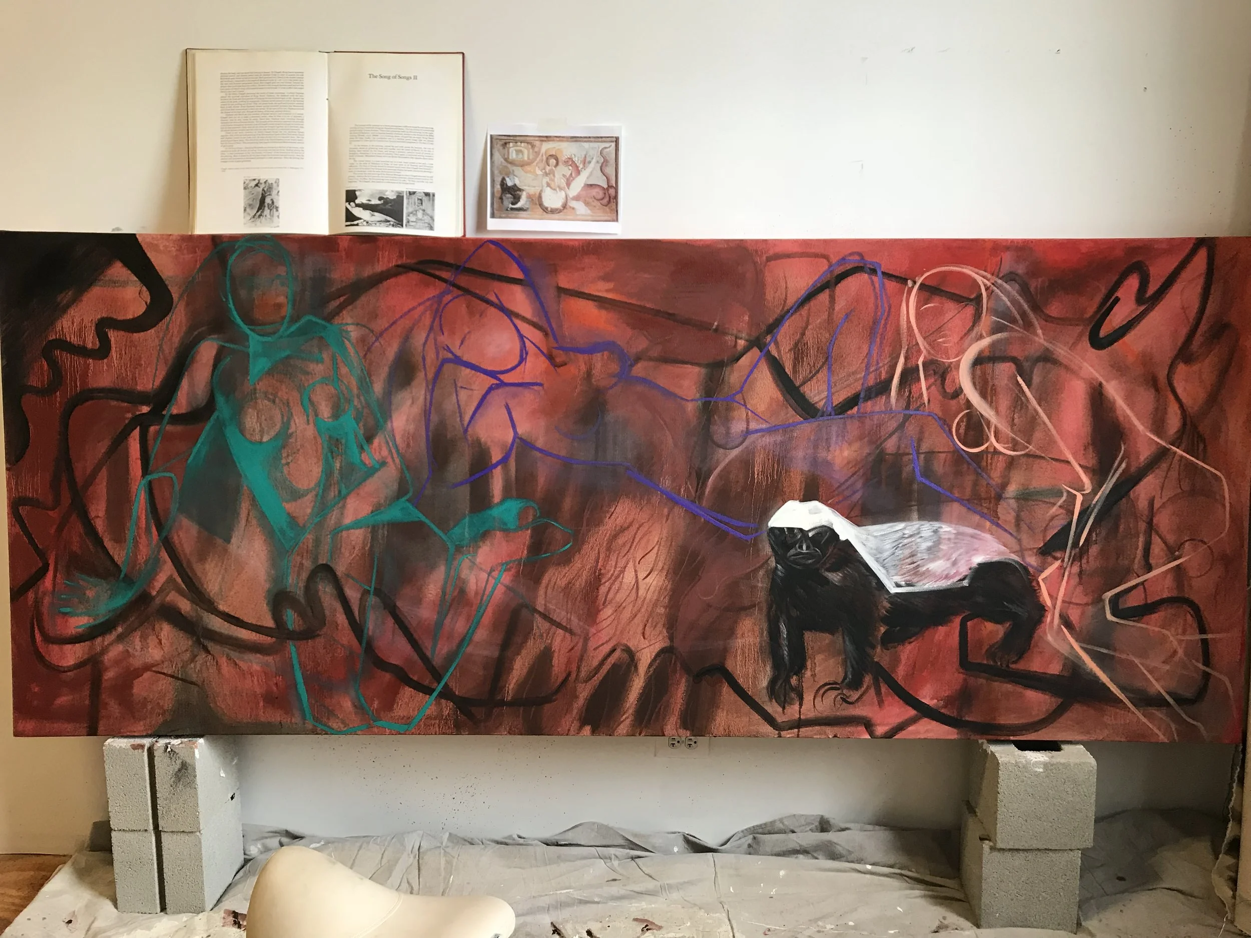 An art installation featuring an abstract painting on a red background with black, blue, teal, and pink lines, placed on a white display stand against a white wall, with an open book and a reference image above.