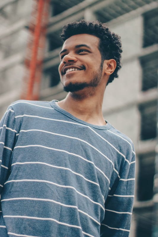 a smiling man in a stripped shirt