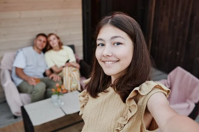 A happy teen and parents behind