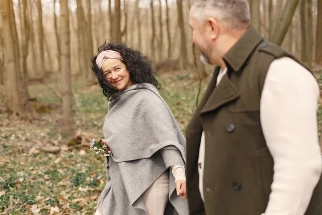 A woman and man holding hands walking