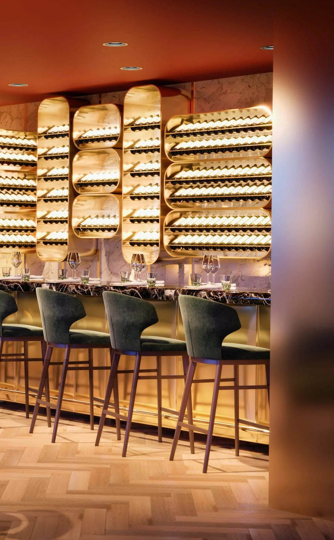 Binnenkant van een bar of restaurant met een wijnrek op de muur, een marmeren bar en vier groene barkrukken.