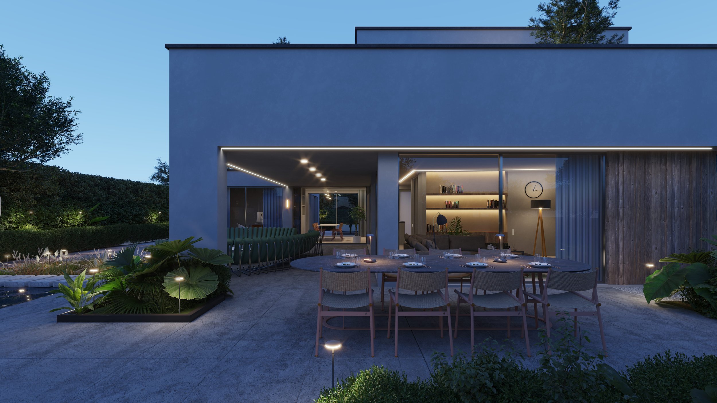Moderne achtertuin met eettafel, tuinmeubels, planten en buitenverlichting, met een moderne woning op de achtergrond in de avond.