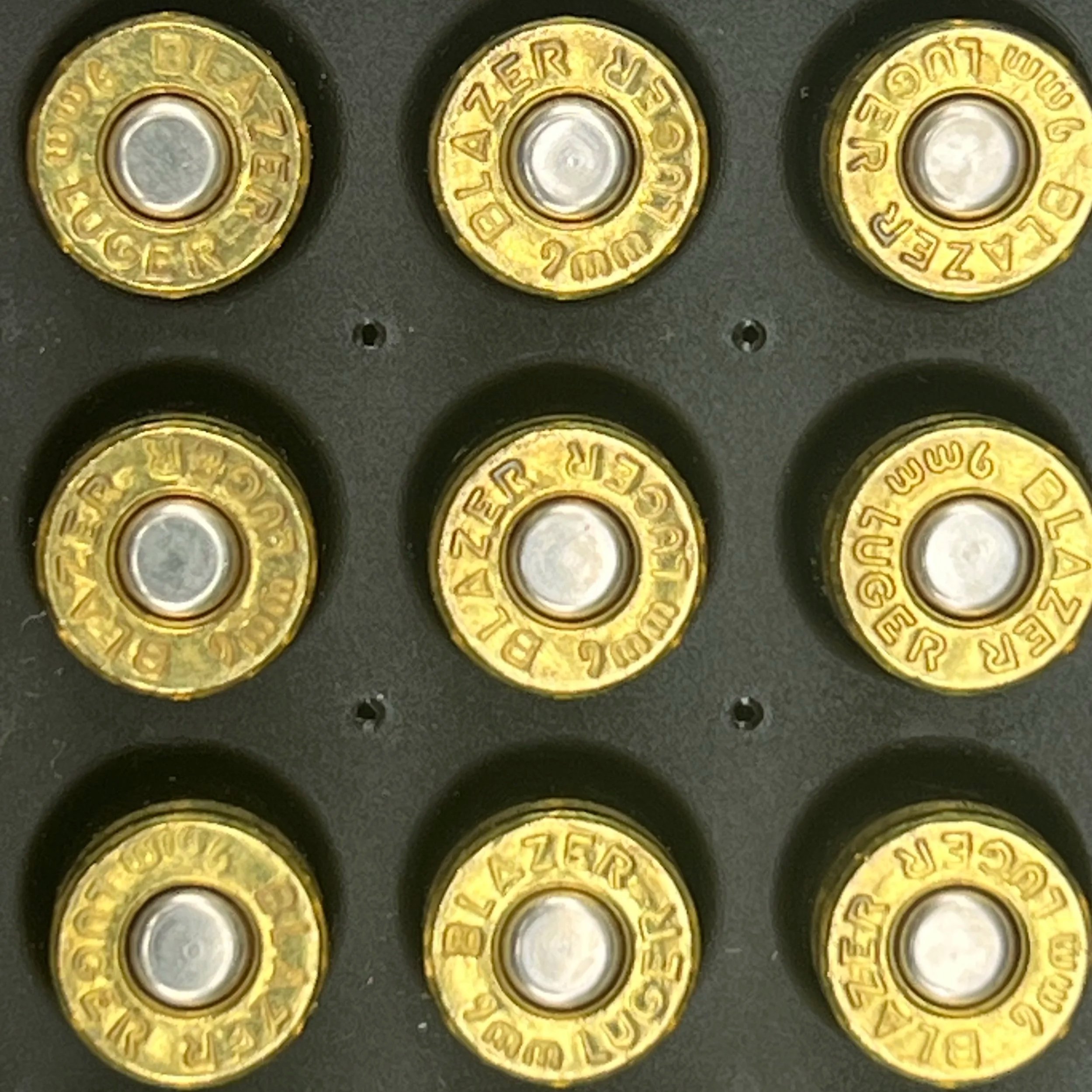 Close-up of multiple brass cartridge cases with the headstamp '7mm REM MAG' arranged in a tray.