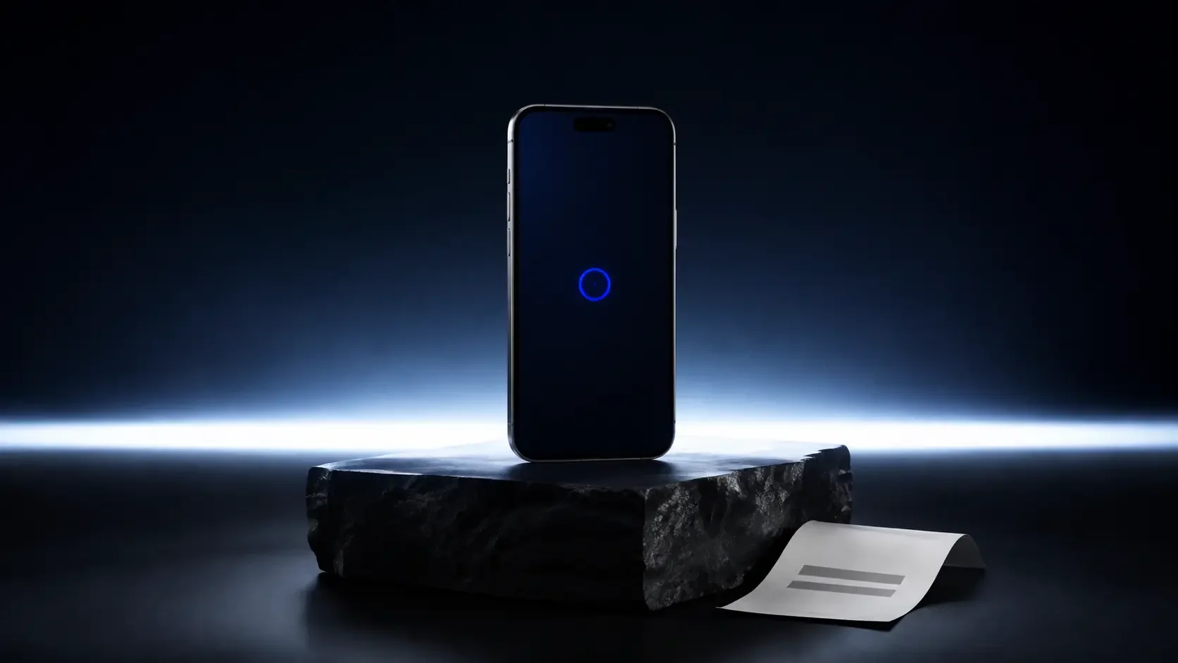 An unbranded graphite smartphone stands on a dark stone plinth at the edge of first light.