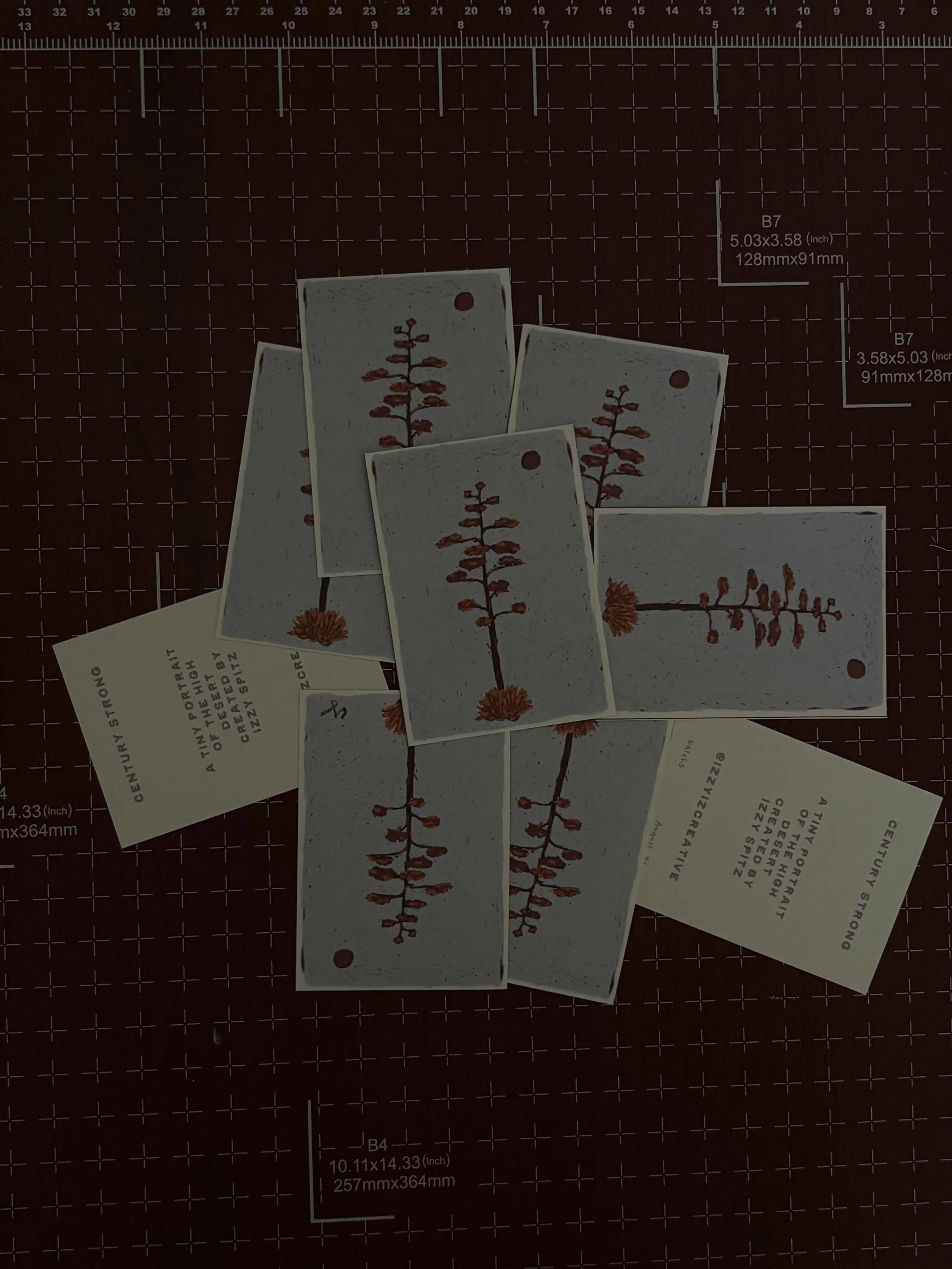 Multiple plant labels with illustrations of plants and parts, arranged on a cutting mat with measurement markings.