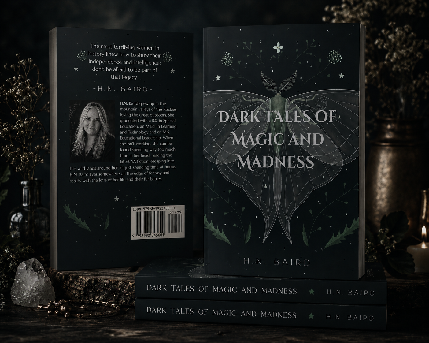 Open book titled 'Dark Tales of Magic and Madness' by H.N. Baird, displayed on a dark surface with decorative items and candles in the background.