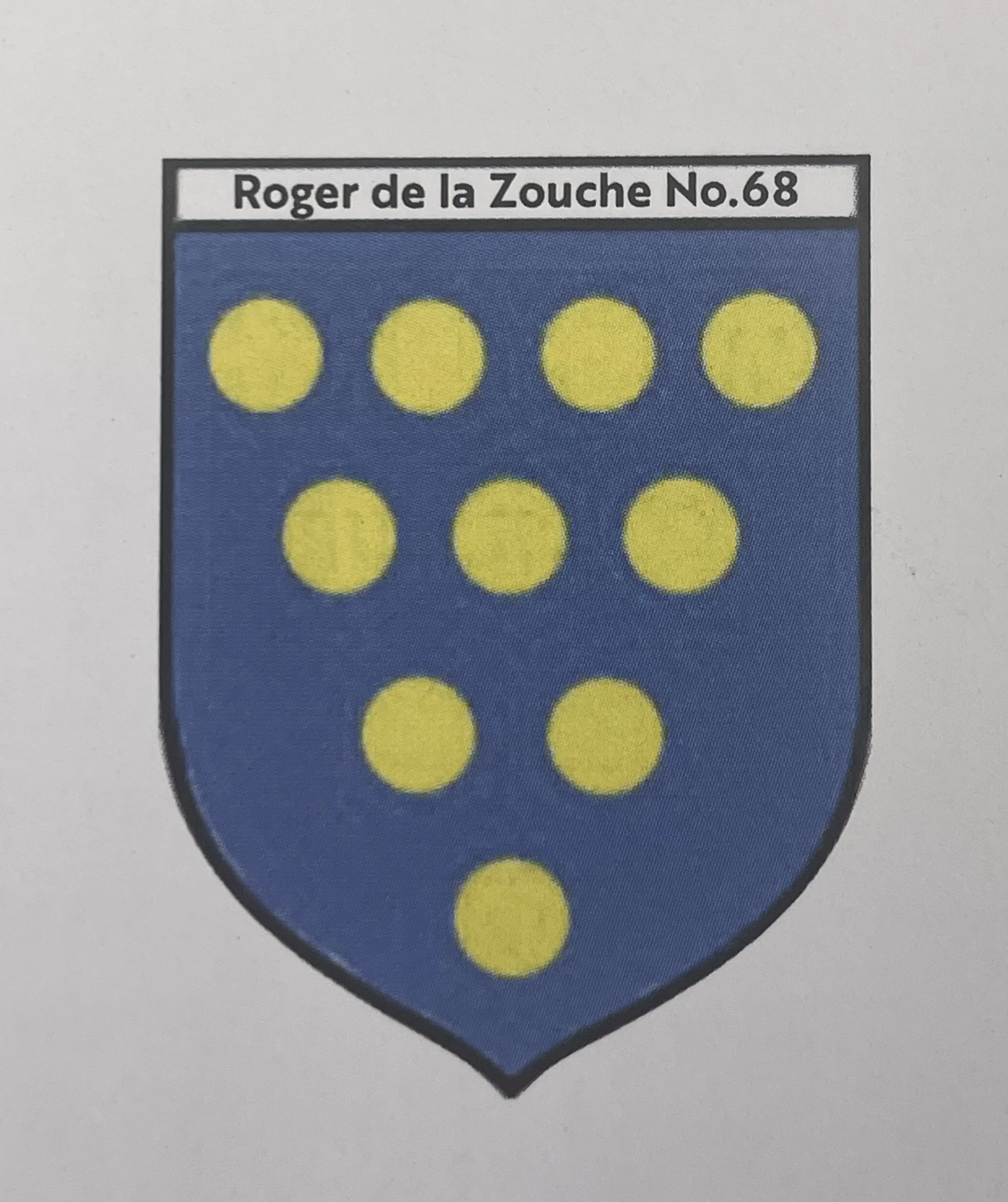 A shield-shaped emblem with a black border, blue background, and yellow dots arranged in two rows. The top row has four dots, and the bottom row has five dots. Above the shield, there is a white rectangle with black text that says 'Roger de la Zouche No. 68'.