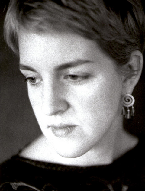 Black and white close-up portrait of a woman with short hair and earrings, looking down.