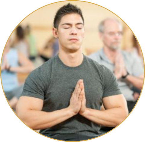 Junger Mann in Meditationshaltung mit geschlossenen Augen in einem Meditationsraum.