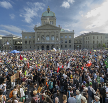 Große Menschenmenge versammelt sich vor einem historischen Gebäude mit einer Kuppel, wahrscheinlich bei einer Demonstration oder Versammlung.