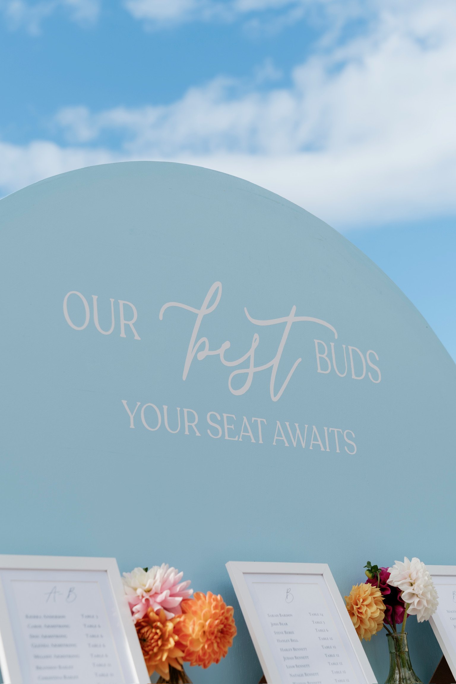 Wedding or event seating chart with flower arrangements and a blue background