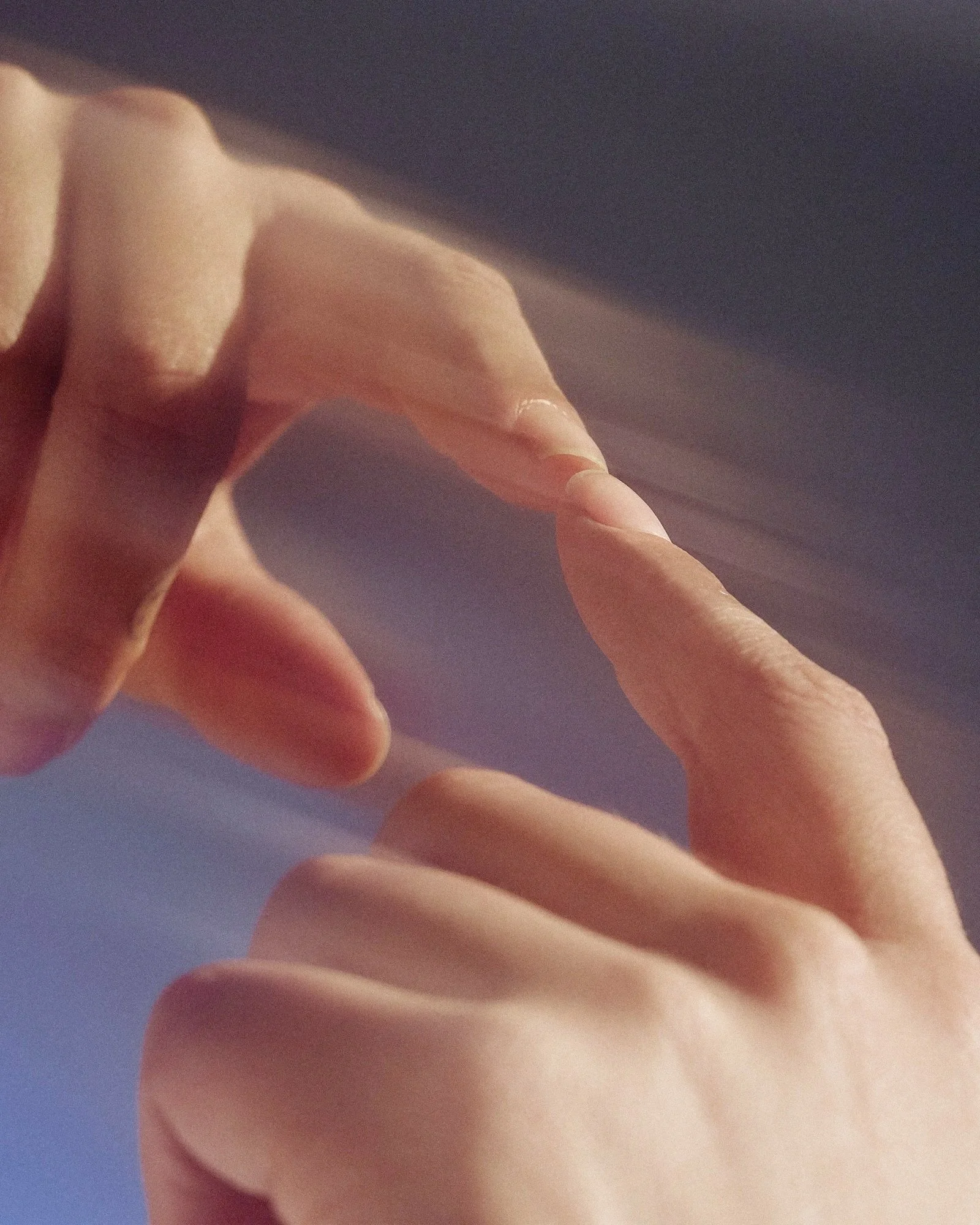 Close-up of a person's hand with fingers extended, against a dark background.