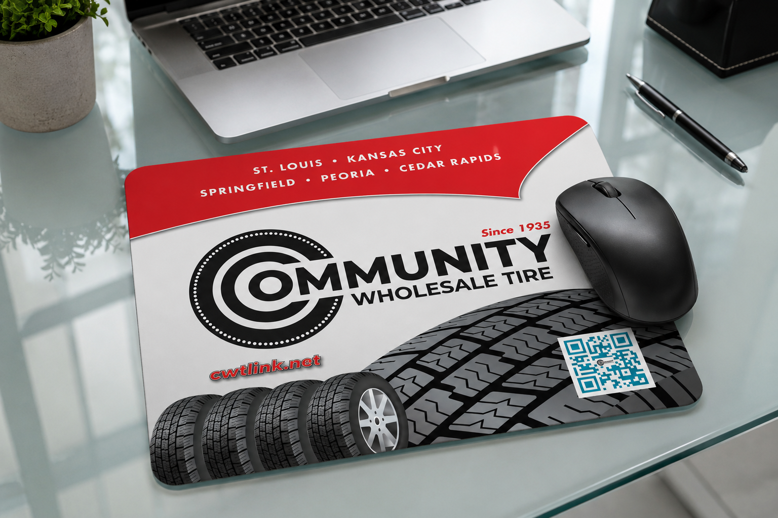 Promotional flyer for Community Wholesale Tire, featuring a tire and QR code, with a black computer mouse placed on top.