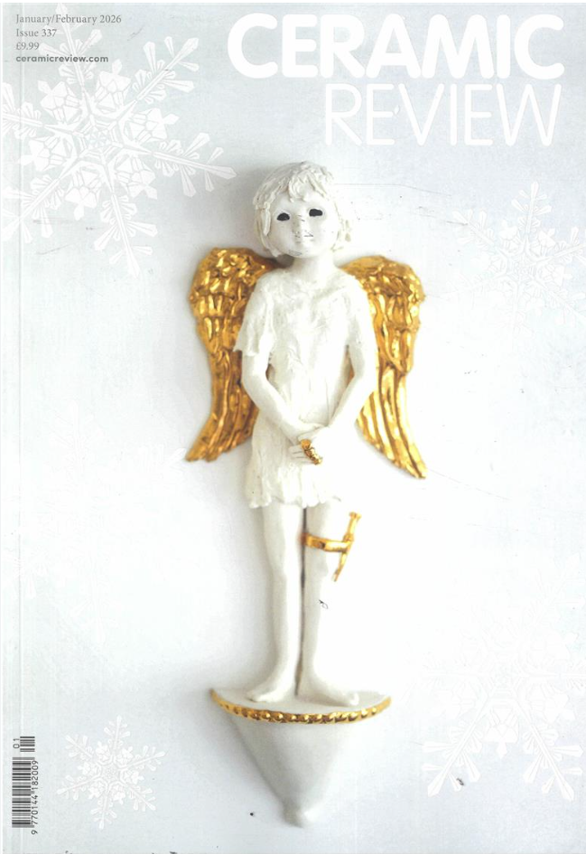 A white ceramic angel figurine with gold wings, standing on a rounded base, with a gold band around its right thigh, on the cover of Ceramic Review magazine, January/February 2026.