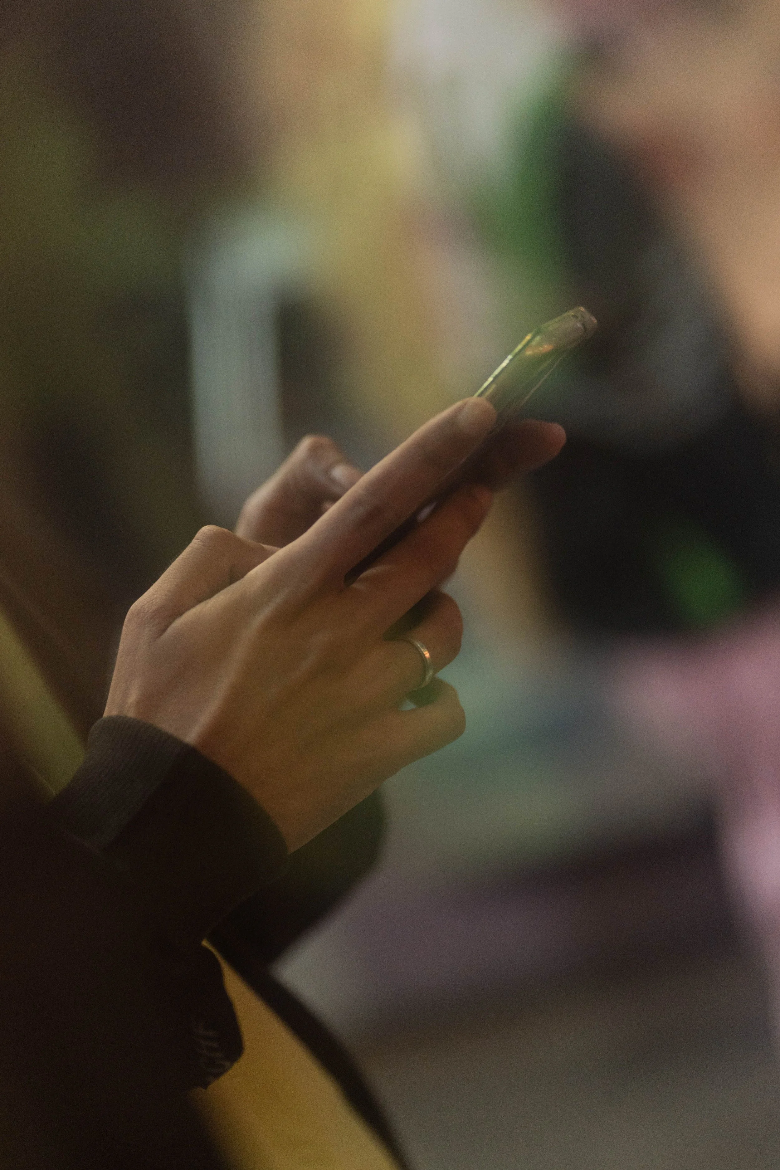 Close-up of a person's hand holding a smartphone, with a blurred background.