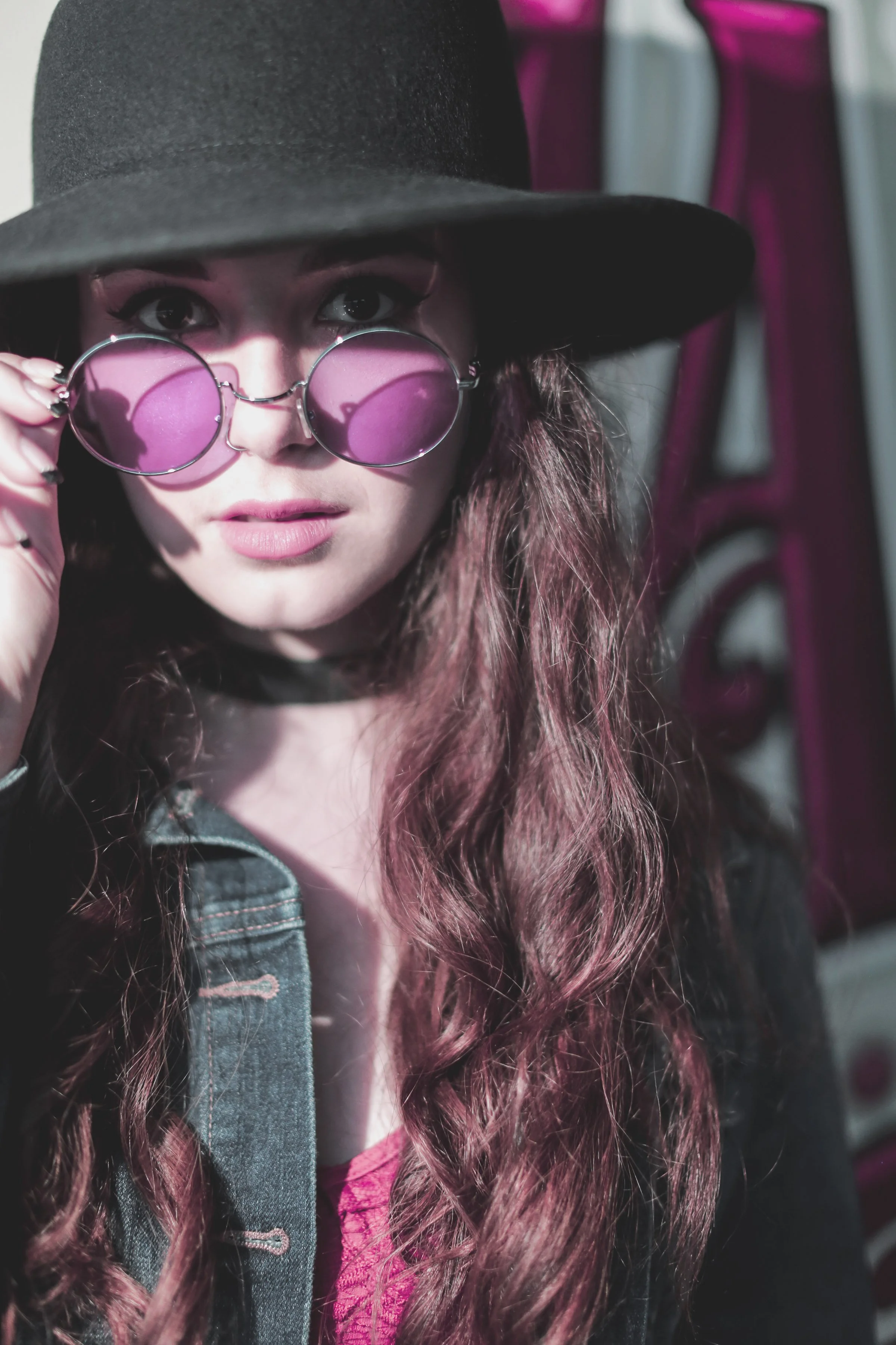 High school senior girl wearing pink sunglasses during a nighttime portrait session at Avila Beach, California.