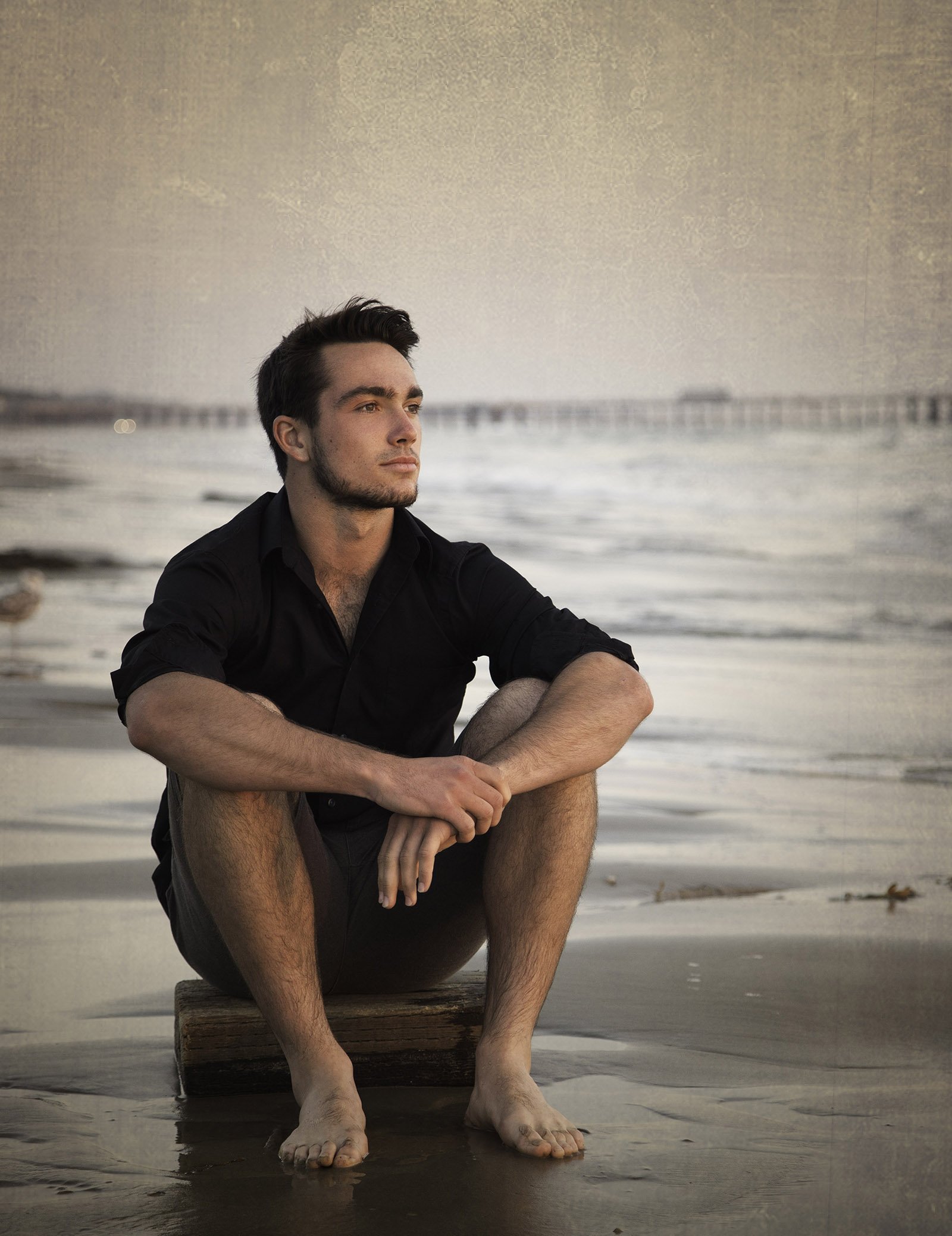 High school senior boy watching the sunset at Shell Beach, California.
