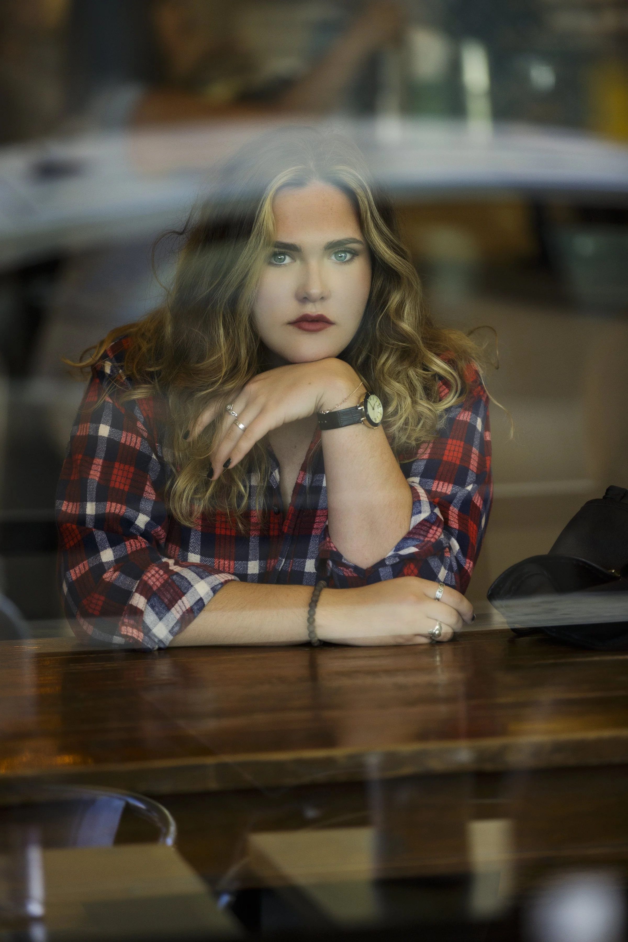 Senior portrait through the window at Kreuzberg Coffee Company in downtown San Luis Obispo.