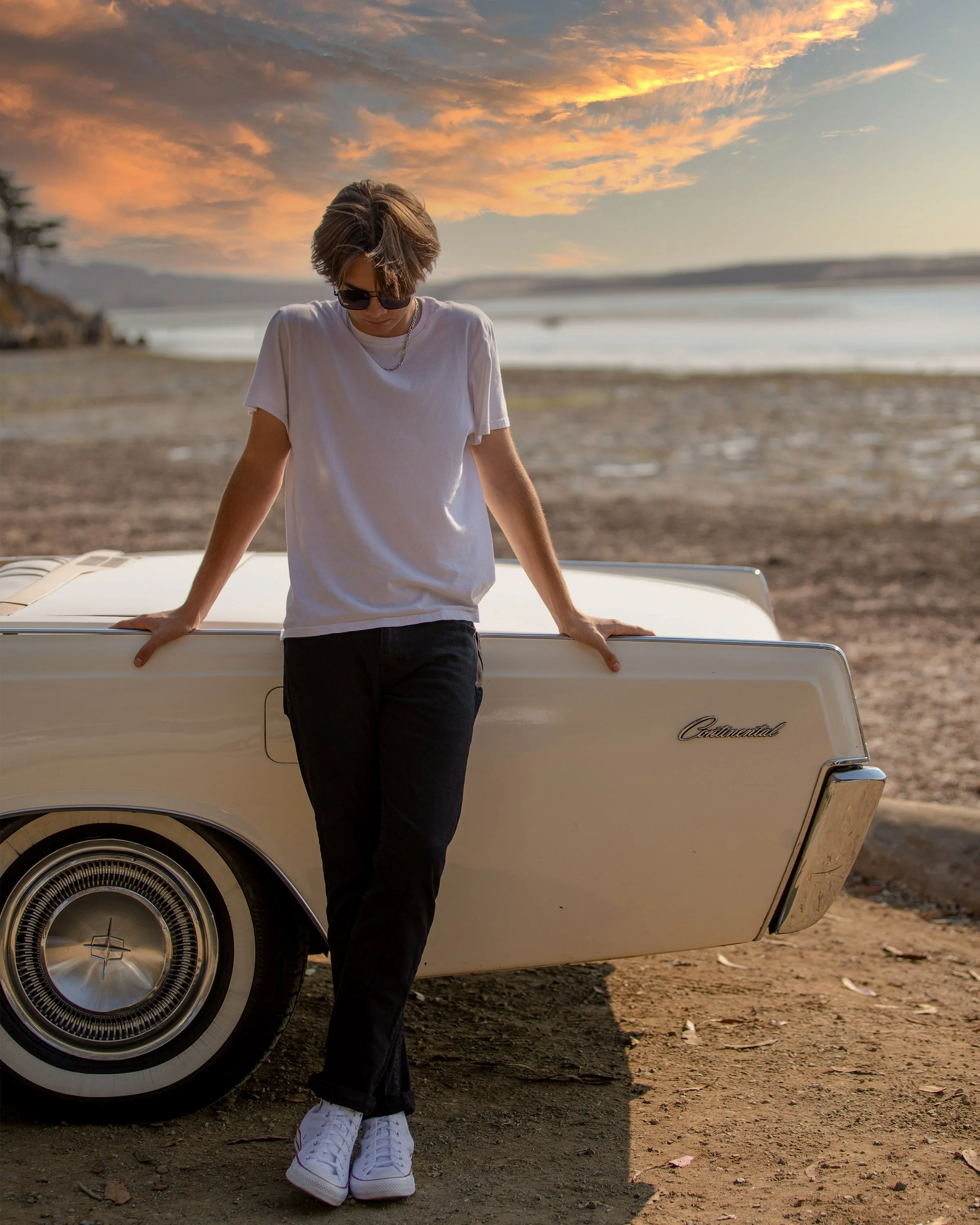 High school senior boy photographed with a classic car at sunset in Morro Bay, California.