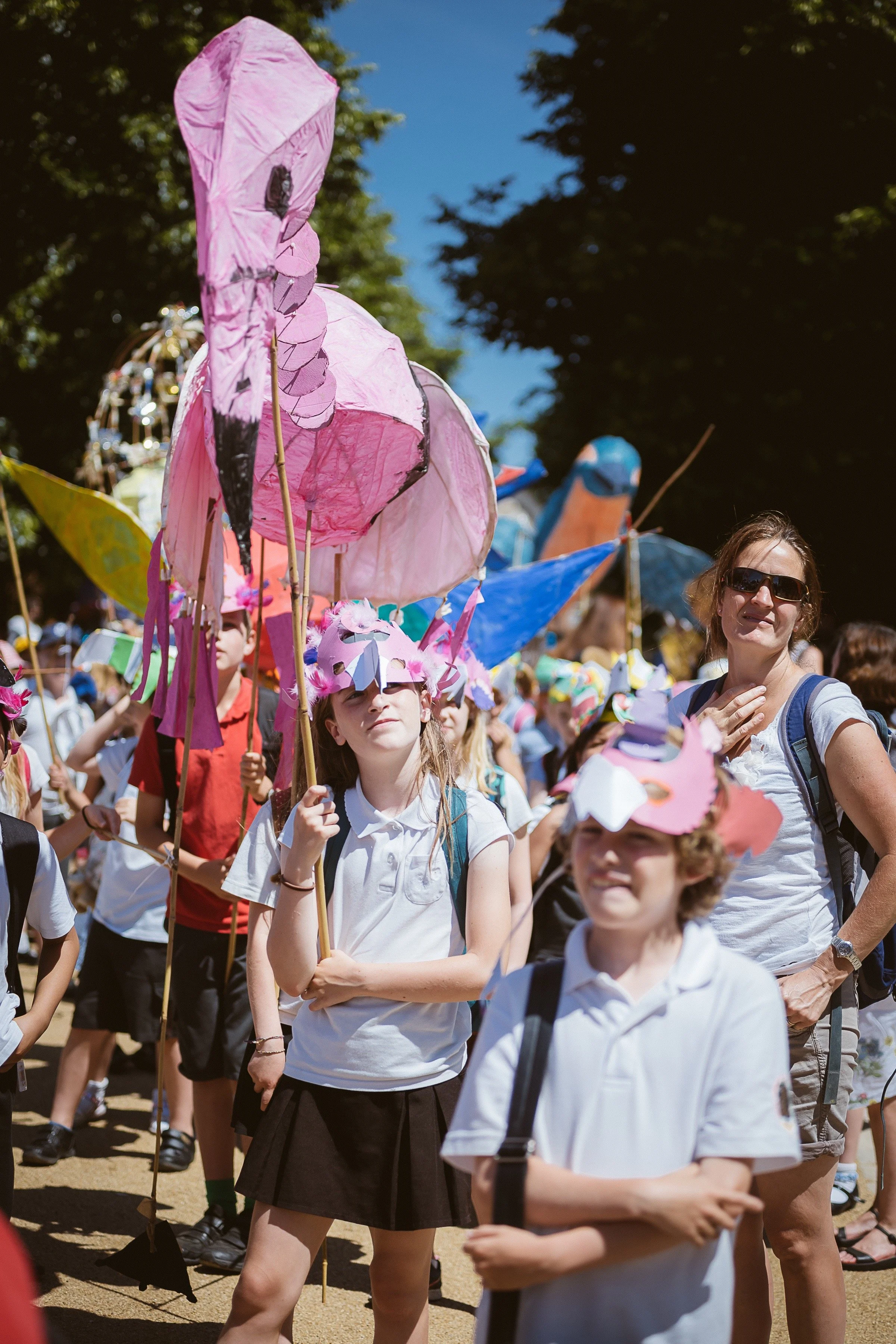 Children taking part in a carnival parade with a large-scale handmade puppet created through a CreatingART participatory art project.