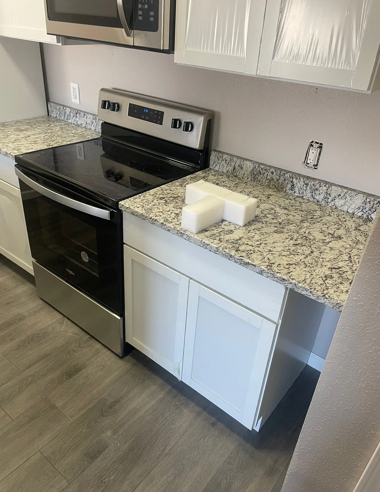 Quartz kitchen countertop with white cabinetry.