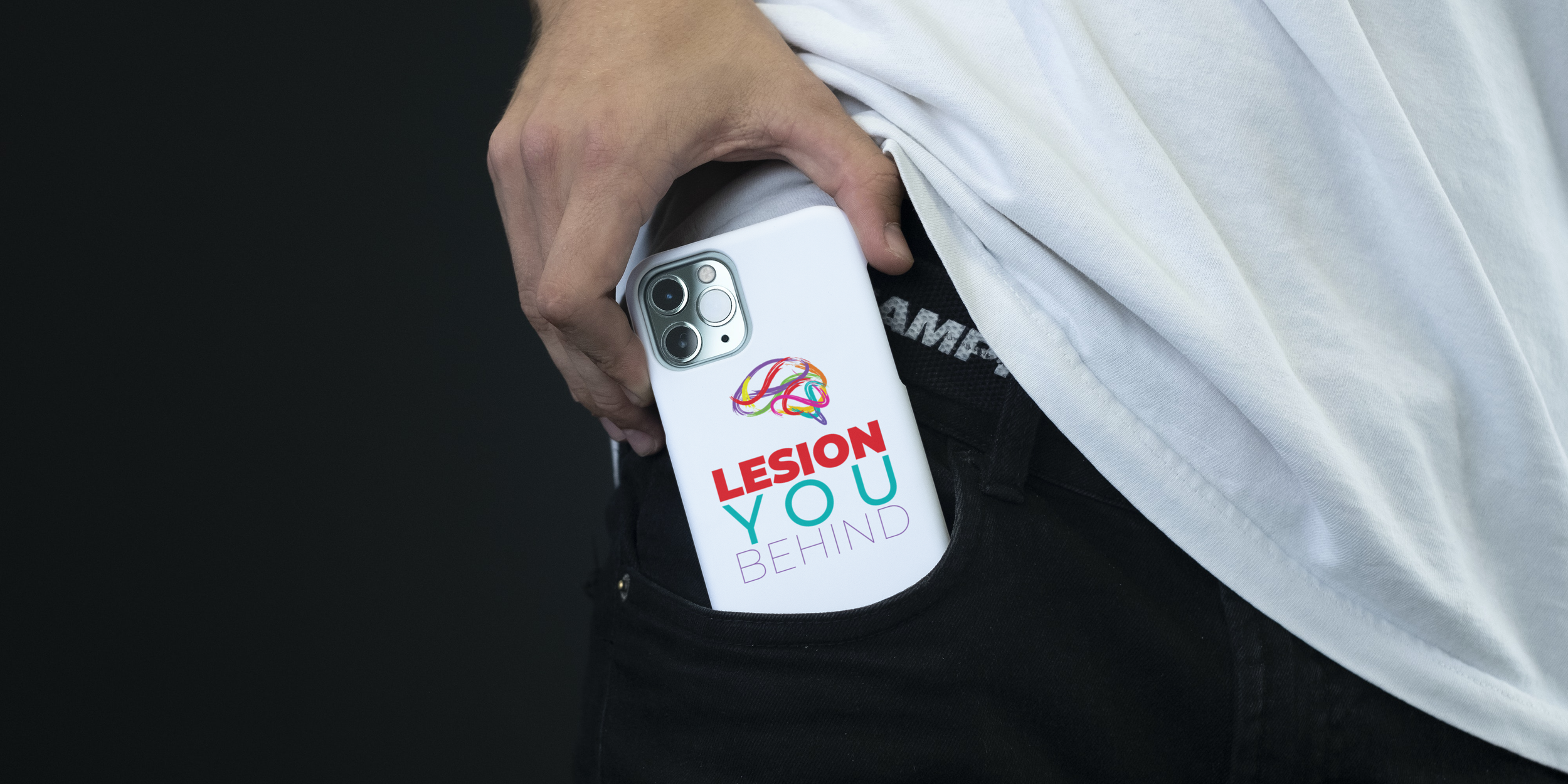 A person wearing a white shirt and black pants has a smartphone in their pocket. The phone has a case with rainbow-colored illustrations and the text "Lesion You Behind."