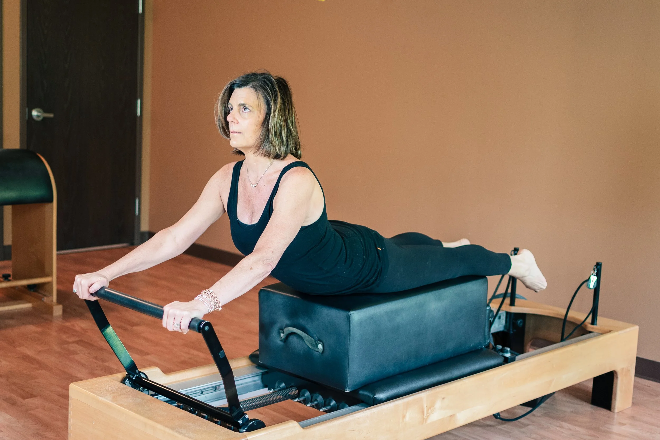 Rebecca Bell demonstrating the Pilates Swan on the pilates reformer at Mindful Movements in Fort Wayne, Indiana